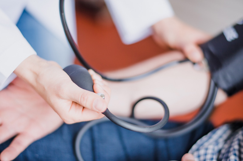 preventive care Doctor performing blood pressure measurement during in-home healthcare visit, emphasizing skilled nursing care and patient monitoring services.
